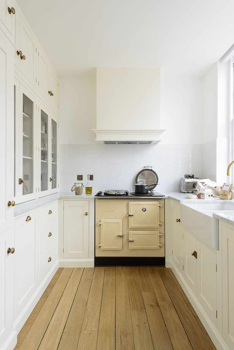 small white kitchen with white cabinets and cream aga
