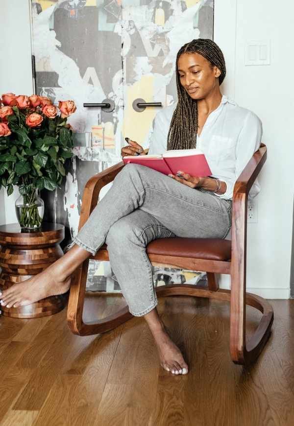 Shanika Hillocks reading on living room chair 2023 books
